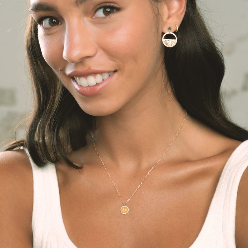 Delicate gold charm pendant necklace featuring a seashell design, perfect for beach lovers. Ideal for casual outings or summer events, this stylish piece adds a touch of elegance to any outfit.