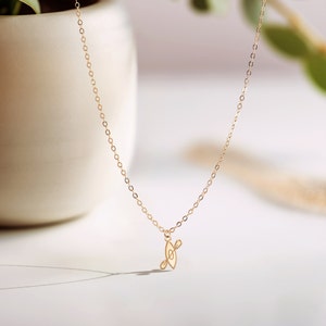 K&ouml;nnte beinhalten: Eine goldene Kettenkette mit einem kleinen, filigranen Anh&auml;nger in Form eines Kanus mit Paddeln. Die Kette liegt auf einem wei&szlig;en Hintergrund.