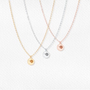 May include: Three delicate necklaces with a table tennis paddle pendant. The necklaces are gold, silver, and rose gold.
