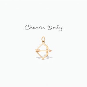 Könnte beinhalten: Ein goldfarbener Metallanhänger in Form von Pfeil und Bogen mit einem kleinen runden Ring an der Oberseite zur Befestigung. Der Text "Charm Only" ist in schwarzer Schreibschrift über dem Schmuckstück gedruckt, das ein schlichtes, offenes Design aufweist.