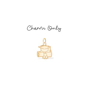 Puede incluir: Un dije dorado con un gorro de graduación y un diploma. El dije tiene un lazo en la parte superior para sujetarlo a un collar o pulsera. El texto "Charm Only" está escrito en cursiva.