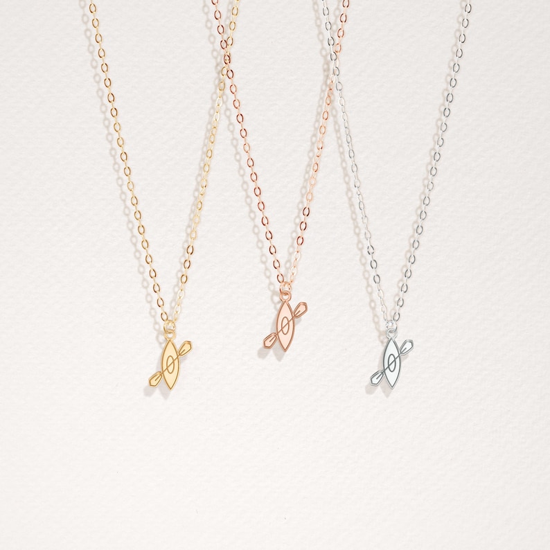 K&ouml;nnte beinhalten: Drei zarte Halsketten mit einem schlichten Kanu-Anh&auml;nger. Die Halsketten sind in Gold, Ros&eacute;gold und Silber erh&auml;ltlich.