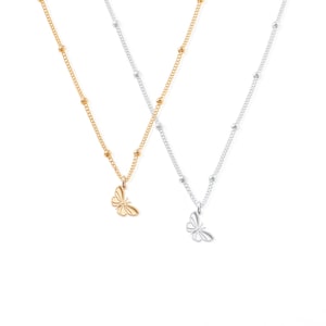 Pode incluir: Dois colares delicados com pingentes de borboleta. Um colar &eacute; dourado com um pingente de borboleta dourado, e o outro &eacute; prateado com um pingente de borboleta prateado.