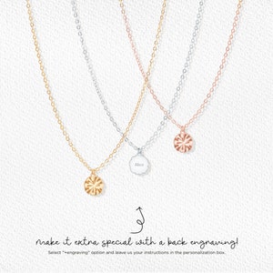May include: Three delicate necklaces in gold, silver, and rose gold. Each necklace features a small, round pendant with a sunburst design. One pendant is engraved with the name "Alice". The image includes text that reads "make it extra special with a back engraving!"