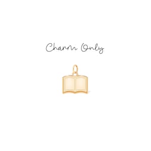 Può includere: Un ciondolo color oro a forma di libro aperto. Il ciondolo ha un anello nella parte superiore per il fissaggio a una collana o un braccialetto. Le parole "Charm Only" sono scritte in corsivo sopra il ciondolo.