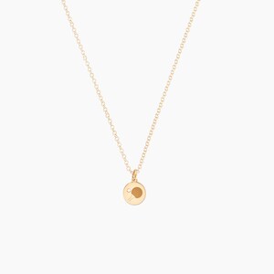 May include: A gold chain necklace with a small gold pendant featuring a table tennis bat and ball.