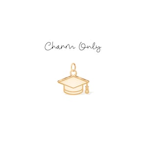 May include: A gold-colored graduation cap charm with a white top and a dangling tassel. The charm is shown on a white background. The text "Charm Only" is written in cursive above the charm.