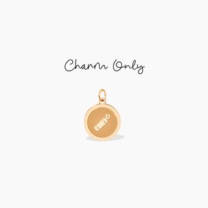May include: Gold charm with a small, detailed image of a spray bottle inside a round, gold frame.