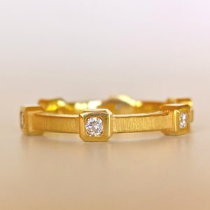 K&ouml;nnte beinhalten: Ein Goldring mit f&uuml;nf kleinen Diamanten, die in quadratischen Krappen gefasst sind.