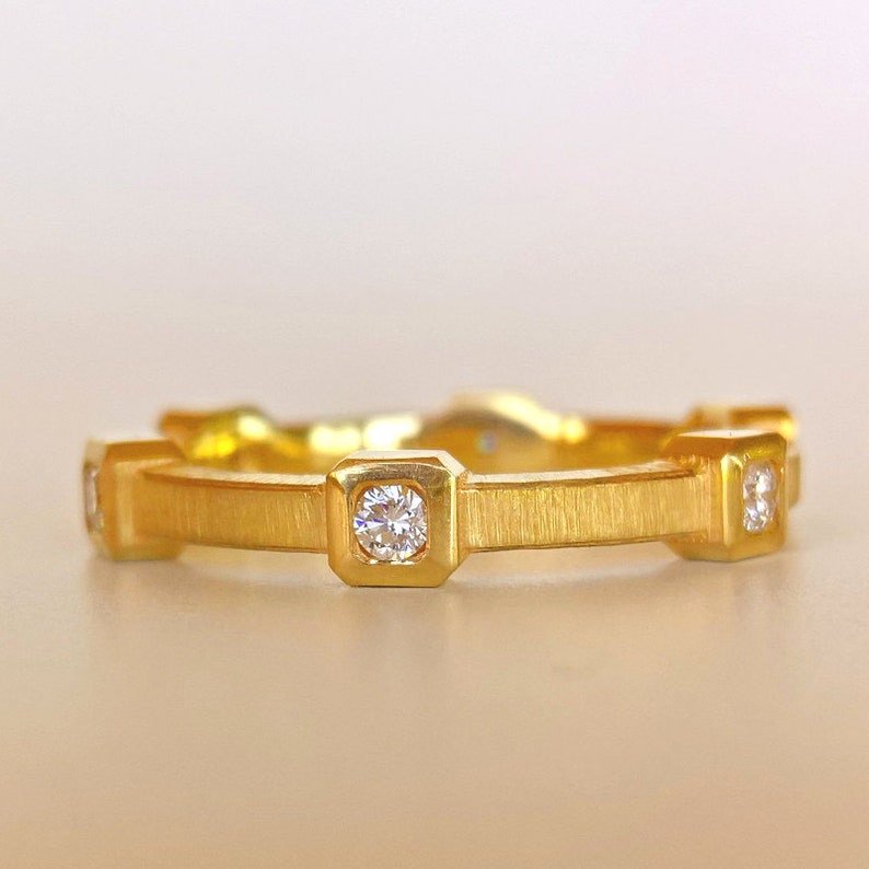 K&ouml;nnte beinhalten: Ein Goldring mit f&uuml;nf kleinen Diamanten, die in quadratischen Krappen gefasst sind.