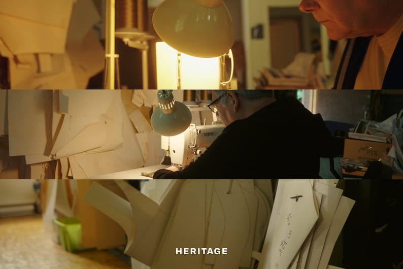 K&ouml;nnte beinhalten: Ein Mann arbeitet an einer N&auml;hmaschine in einer Werkstatt, die mit Stoffresten und Mustern gef&uuml;llt ist. Das Wort "HERITAGE" ist unten in der Mitte des Bildes zu sehen.