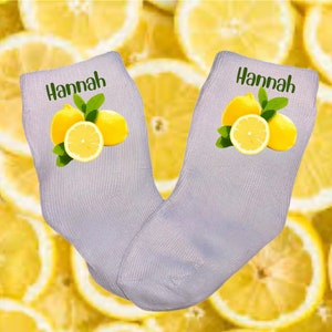 Könnte beinhalten: Ein Paar graue Socken mit einem Zitronenmotiv und dem Namen "Hannah" auf jeder Socke.