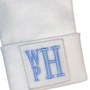 May include: White beanie with a blue embroidered patch that says "WH" in a white square.