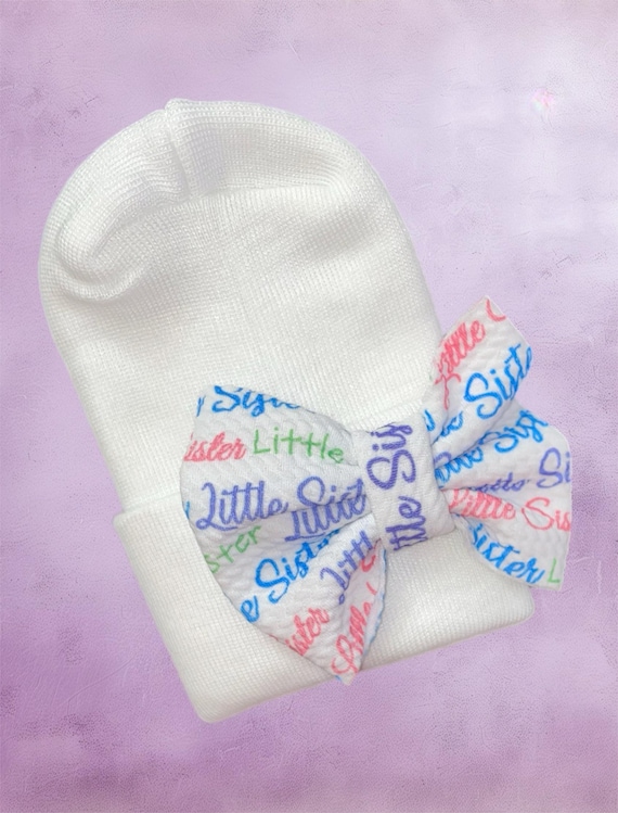 Little Sister Bow Newborn Hat. Perfect for the arrival of your Baby Girl. White hat with Little Sister bow as pictured.