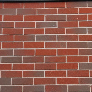 May include: A brick wall with alternating red and brown bricks. The bricks are arranged in a staggered pattern, creating a traditional brick wall look.
