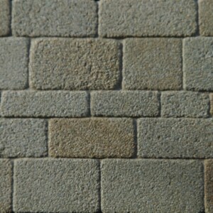 May include: A close-up of a wall made of rough, textured stone blocks. The blocks are arranged in a staggered pattern, with some blocks being a lighter brown color than others.