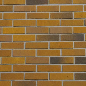 May include: A brick wall with a staggered pattern of light brown and dark brown bricks.