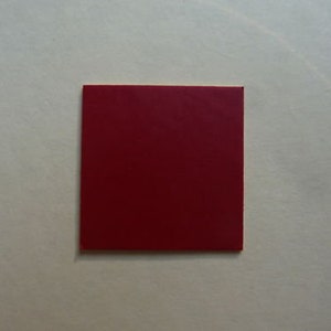 Puede incluir: Un cuadrado de papel rojo.