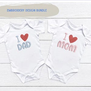 Puede incluir: Dos bodies blancos para bebé con texto bordado y diseños de corazón. Uno dice "I ❤️ DAD" en azul y rojo, el otro dice "I ❤️ MOM" en rosa y rojo. El texto "EMBROIDERY DESIGN BUNDLE" está arriba.