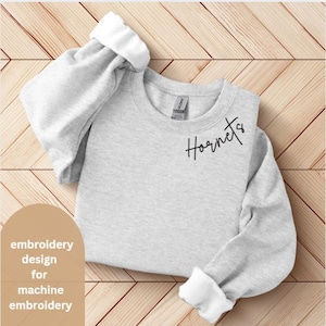 May include: A gray sweatshirt with the word "Hornets" embroidered on the front in black cursive script. This is a machine embroidery design.