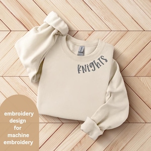 May include: A cream-colored sweatshirt with the word "Knights" embroidered in gray on the front.
