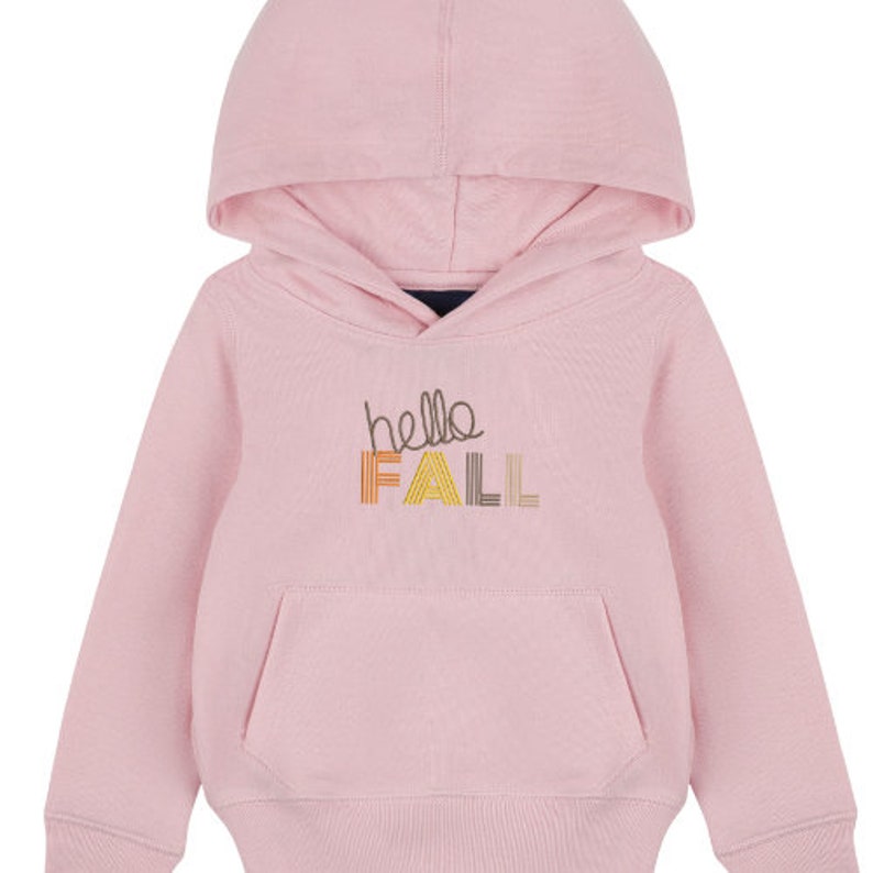 Puede incluir: Una sudadera con capucha rosa con el texto "hello fall" en letras bordadas de colores.