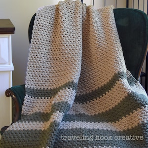 May include: A crocheted throw blanket with stripes of beige and green yarn draped over a chair. The blanket has a textured stitch pattern. The text "traveling hook creative" is visible in the bottom right corner of the image.