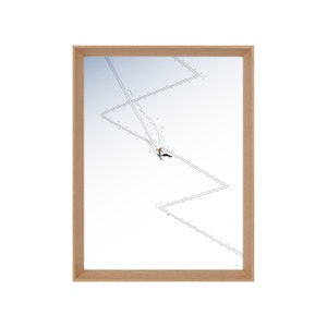 Op de afbeelding: Een ingelijste zwart-witte illustratie van een skiër die een zigzaggende skipiste afdaalt. De skiër is getekend in een eenvoudige stijl met een paar lijnen en stippen.