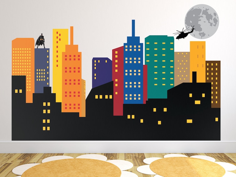 May include: A colourful cityscape wall decal featuring a black silhouette of a superhero standing on a building, a helicopter flying above, and a grey moon in the background.