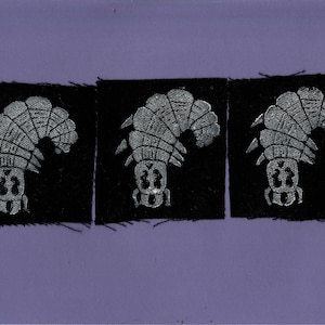 May include: Three black fabric patches with a silver embroidered design of a stylized insect. The insect is facing left and has a segmented body and legs.