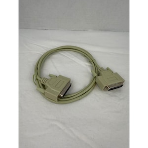 May include: A beige parallel port cable with two connectors. The cable is coiled and lies on a white surface. The connectors have metal pins and are rectangular in shape.