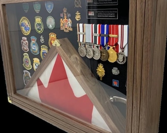Op de afbeelding: Een houten schaduwdoos displaykast met een Canadese vlag, medailles en badges. De tekst op de plaquette luidt "Chief Petty Officer 1st Class Dave Skinner, Chief Petty Officer, Maritime Forces Atlantic Headquarters".