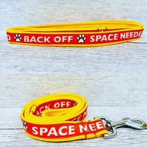 May include: Yellow and red dog leash with the text "Back Off Space Needed" and a paw print graphic.