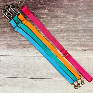 Puede incluir: Tres correas para perros en diferentes colores: turquesa, naranja y rosa. Las correas est&aacute;n hechas de un material tejido duradero y tienen un clip de metal en el extremo.