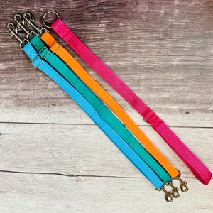 Puede incluir: Tres correas para perros en diferentes colores: turquesa, naranja y rosa. Las correas est&aacute;n hechas de un material duradero tejido y tienen clips de metal plateado.