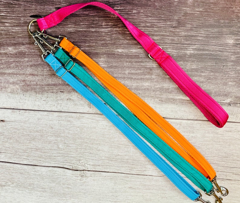 Multiple dog walking lead with a short padded handle and two adjustable dual lead attachments, each with trigger hooks at both ends, connected by a welded O-ring. Cushioned webbing in a choice of colours. Handmade by Dottie's Pet Boutique.