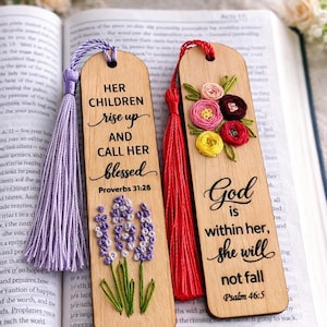 May include: Wooden bookmarks with inspirational quotes and embroidered floral designs. One bookmark features lavender embroidery and the text "Her children rise up and call her blessed." The other has a floral design and the text "God is within her, she will not fall."