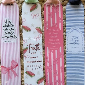 May include: Four decorative bookmarks with fabric ribbons. One bookmark has pink stripes, a bow, and the text "His mercies are new every morning." Another has books, bows, and the text "Faith can move mountains." The third has pink stripes, bows, and the text "I can do all things." The last has blue stripes and the text "Faith can move mountains."