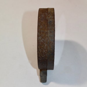 Pu&ograve; includere: Un manometro in metallo arrugginito con un gambo filettato. Il manometro &egrave; circolare e ha un diametro di circa 7,6 cm.
