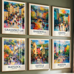 May include: Six framed art prints featuring vibrant, impressionistic paintings of towns such as Grassington and Bakewell. Each print has a white border and a town name in black text at the bottom. The prints are displayed on a green wall.