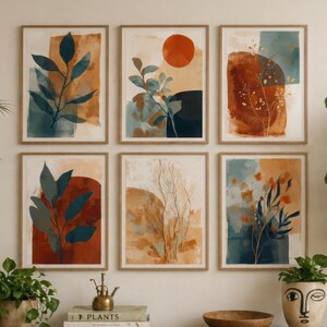 May include: Six framed abstract art prints with botanical themes in shades of blue, orange, and brown. The prints are displayed above a wooden cabinet with plants and decorative items.