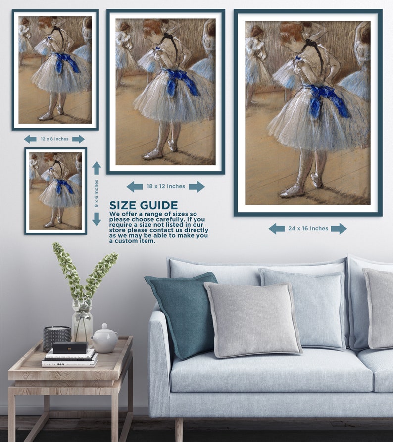 May include: A pastel drawing of a young ballerina in a white tutu with a blue ribbon. The ballerina is standing in a dance studio with other dancers in the background. The drawing is framed in a dark blue frame.