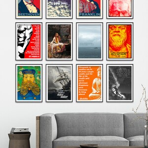 May include: A collage of nine framed posters with inspirational quotes and images. The posters are hung on a white wall above a gray couch and a wooden coffee table. The posters feature images of Beethoven, Franklin, a surfer, a ship, a muscle man, a woman in a field, a man with a beard, and a Buddha.