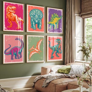 May include: A set of six framed wall art prints featuring stylized illustrations of dinosaurs. The collection includes a red Tyrannosaurus Rex, a teal Triceratops, a yellow Stegosaurus, a pink Brachiosaurus, an orange Pterodactyl, and a blue Velociraptor.
