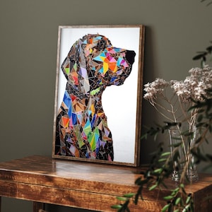 May include: A framed art print of a dog's profile, rendered in a mosaic style with colorful geometric shapes. The artwork features a brown wooden frame and is displayed on a wooden table. The dog's form is composed of various colors.