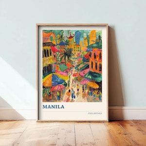 May include: A framed watercolor print of Manila, Philippines, depicting a vibrant street scene with colorful buildings, market umbrellas, and people. The word "MANILA" is printed in blue at the bottom of the print.
