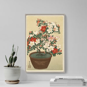 Può includere: Una stampa giapponese vintage su legno che raffigura un'azalea in vaso con fiori rosa e rossi. La pianta è in un vaso marrone con una base verde ed è posizionata su uno sfondo beige chiaro.