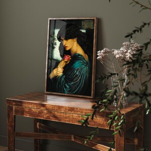 May include: A framed art print featuring a dark-haired figure in a teal velvet garment holding a small red circular object with the text "JUST ONE BITE" printed in white. The figure has pale skin and red lips, set against a dark, moody background.