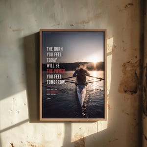 May include: A framed wall art print featuring a rower in a scull on a lake at sunrise. The text reads: THE BURN YOU FEEL TODAY WILL BE THE POWER YOU FEEL TOMORROW. KEEP PULLING. KEEP GROWING. KEEP GOING. The frame is light wood with a dark border.