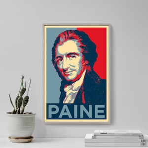 May include: A red, white and blue poster featuring a portrait of Thomas Paine. The poster has the word "PAINE" in large, bold letters at the bottom.